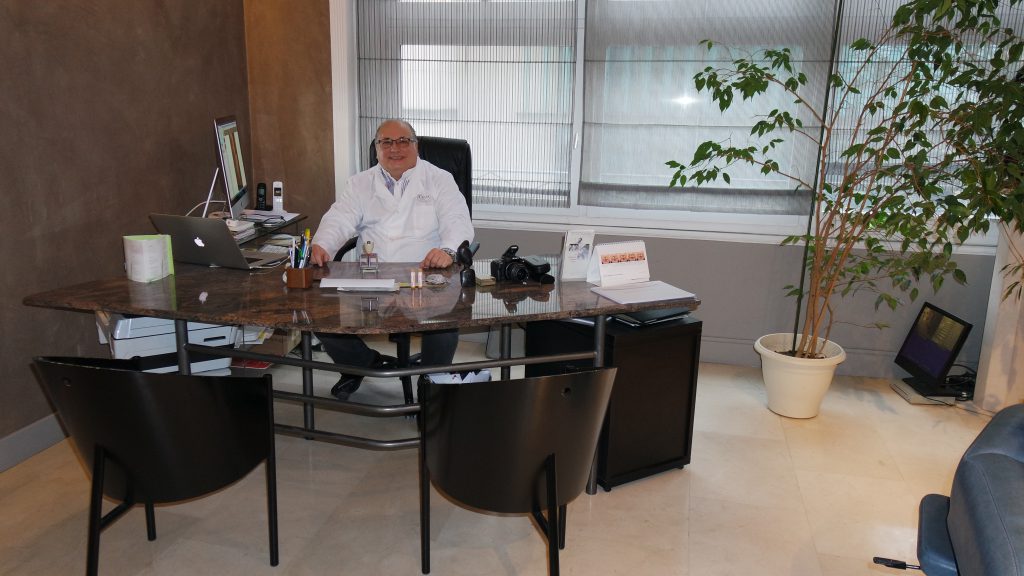 photo du Docteur Gilbert VITALE dans le bureau de sa clinique de chirurgie esthétique à Lyon